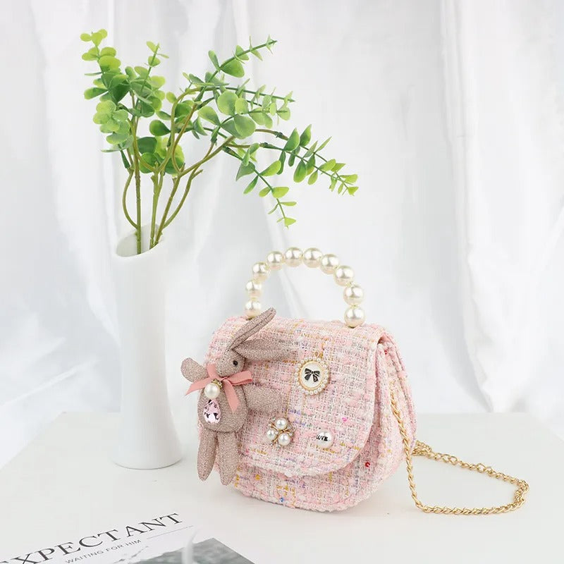Pink tweed purse with a pearl handle and bunny charm.