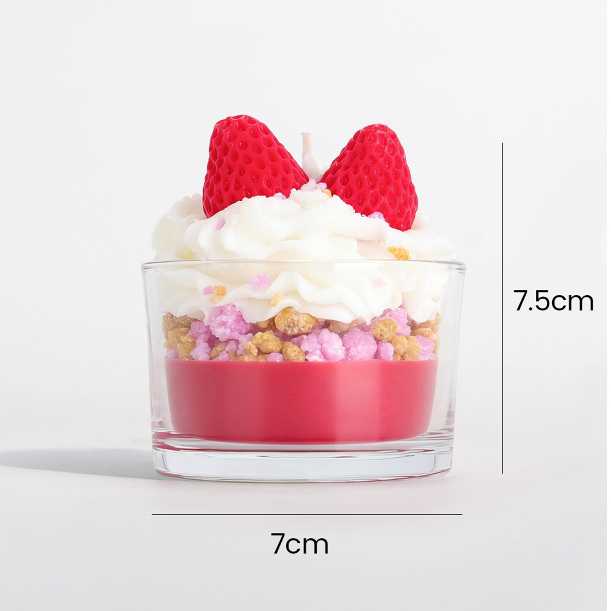 Dessert cup soy wax candle with strawberry toppers, topped with white icing and pink and tan crumbles.