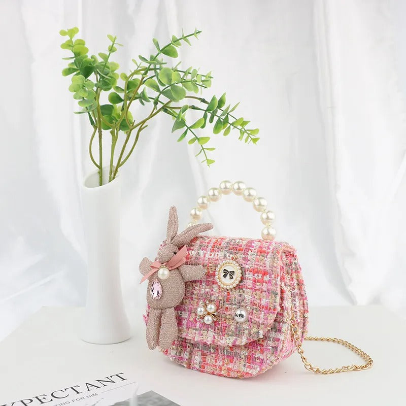 Pink tweed child's purse with pearl handle and bunny charm.
