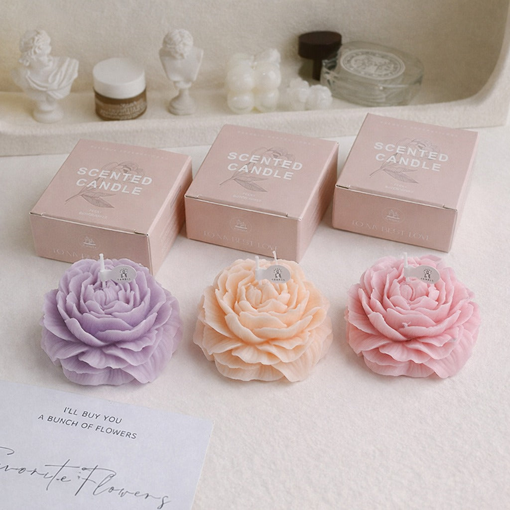 Peonie flower soy wax candles in lavender, peach, and pink, by Jellycup, each with a matching box.