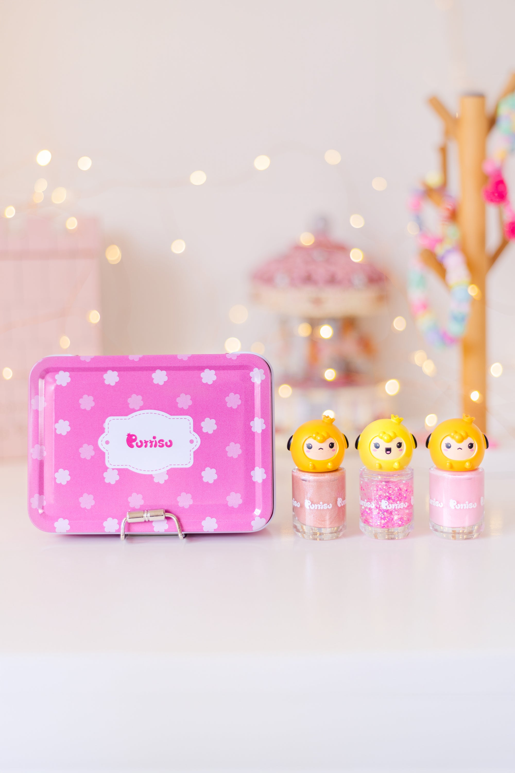 Pink floral tin and three nail polish bottles with cartoon character caps.