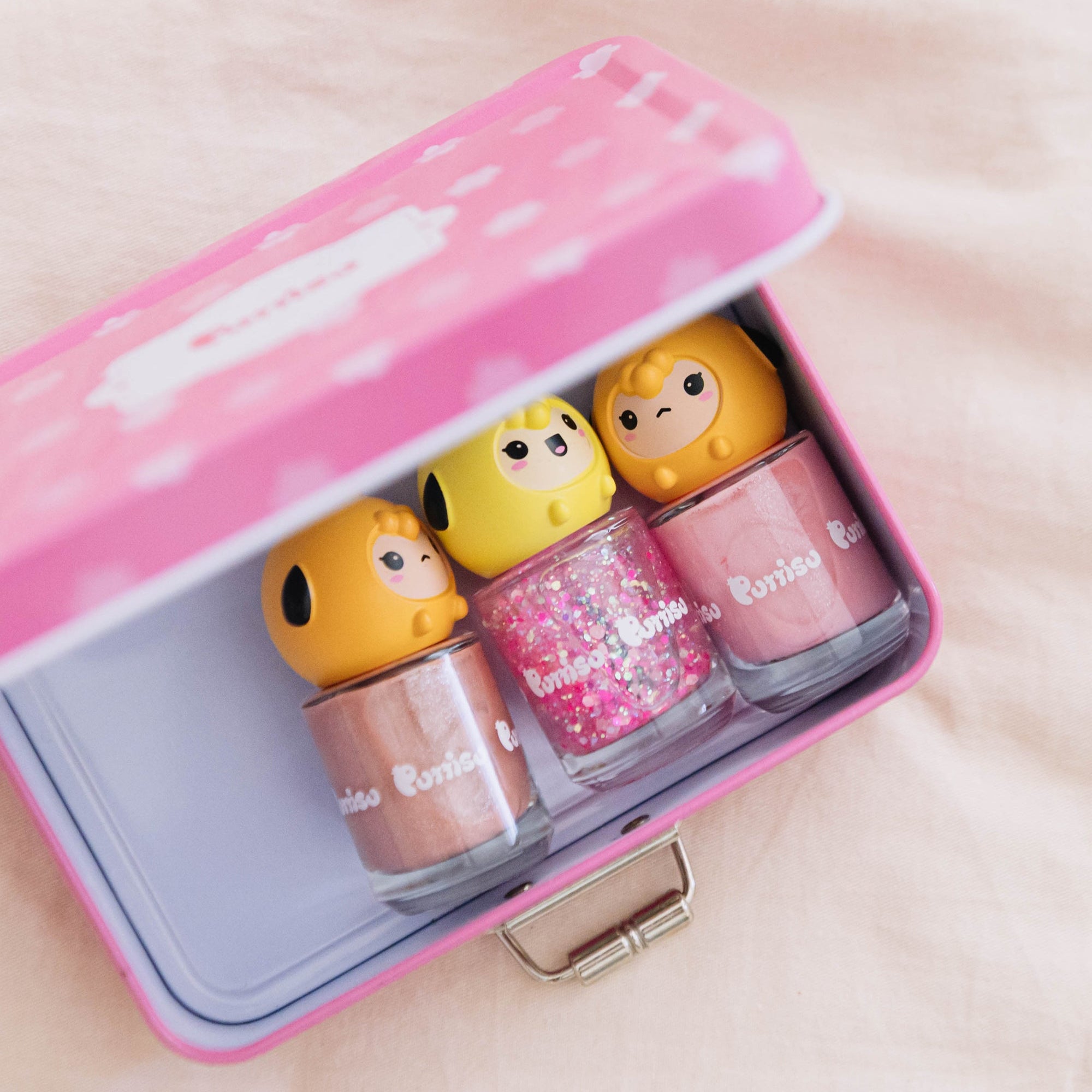 Open pink tin with four colorful bottles of children's nail polish.