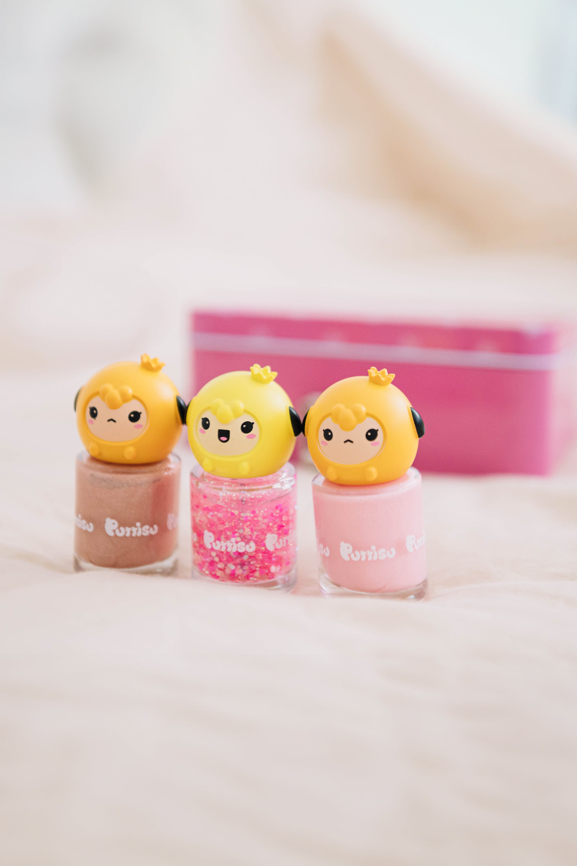 Three bottles of Poriso nail polish with character toppers, each a different color and finish.