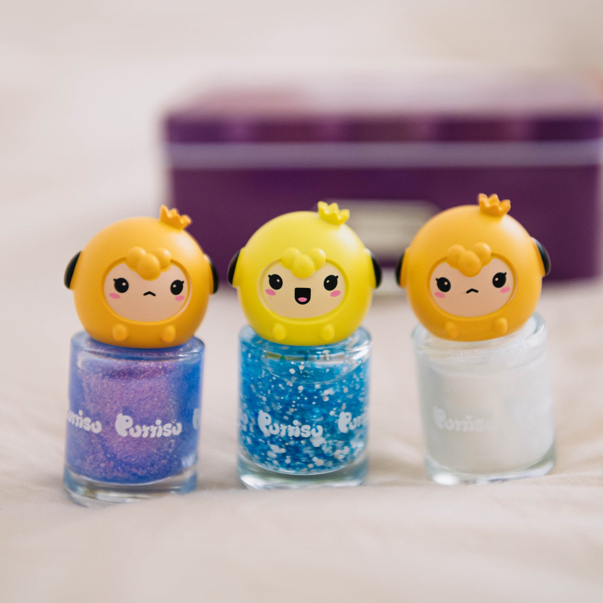 Three small bottles of sparkly nail polish with cartoon character toppers.