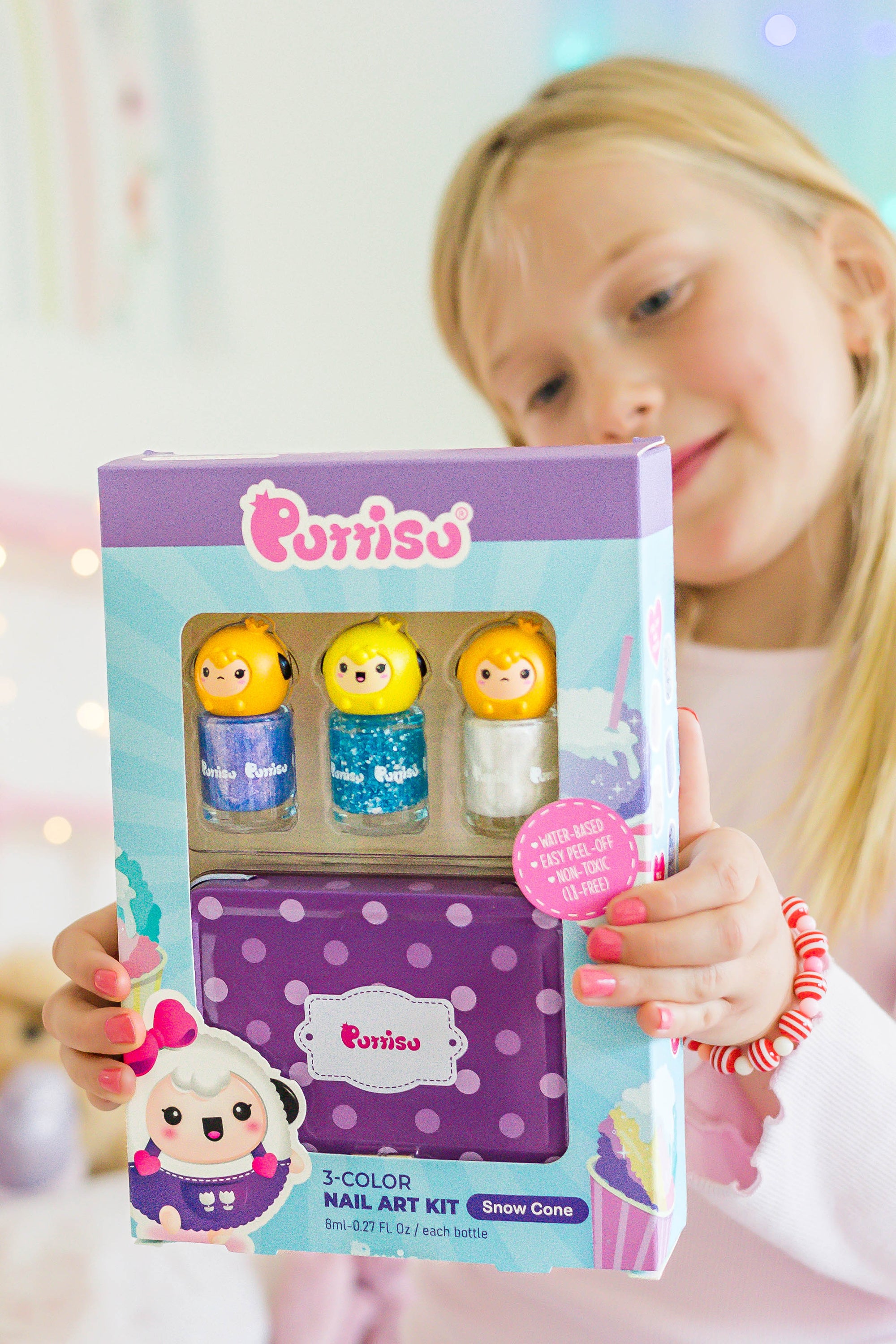 A young girl holds a "Porriso" nail art kit.