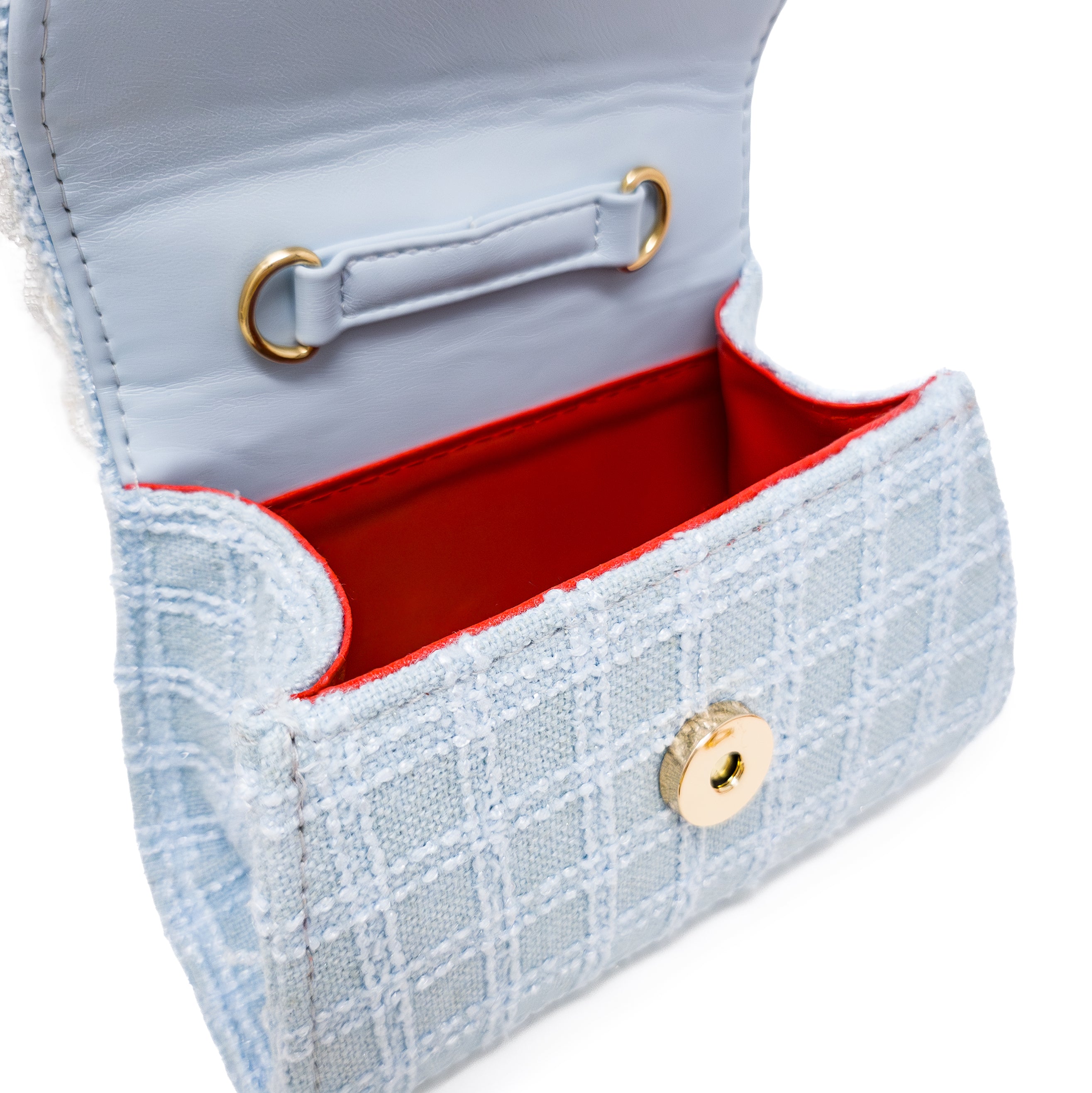 Puttisu Bunny Bloom - power blue. Close-up of a light blue handbag with red interior and gold accents on a white background