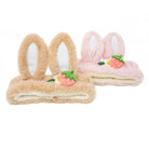 Two headbands with bunny ears and strawberry embellishments, one tan and one pink.