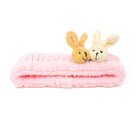 Pink plush headband with two rabbit head decorations.