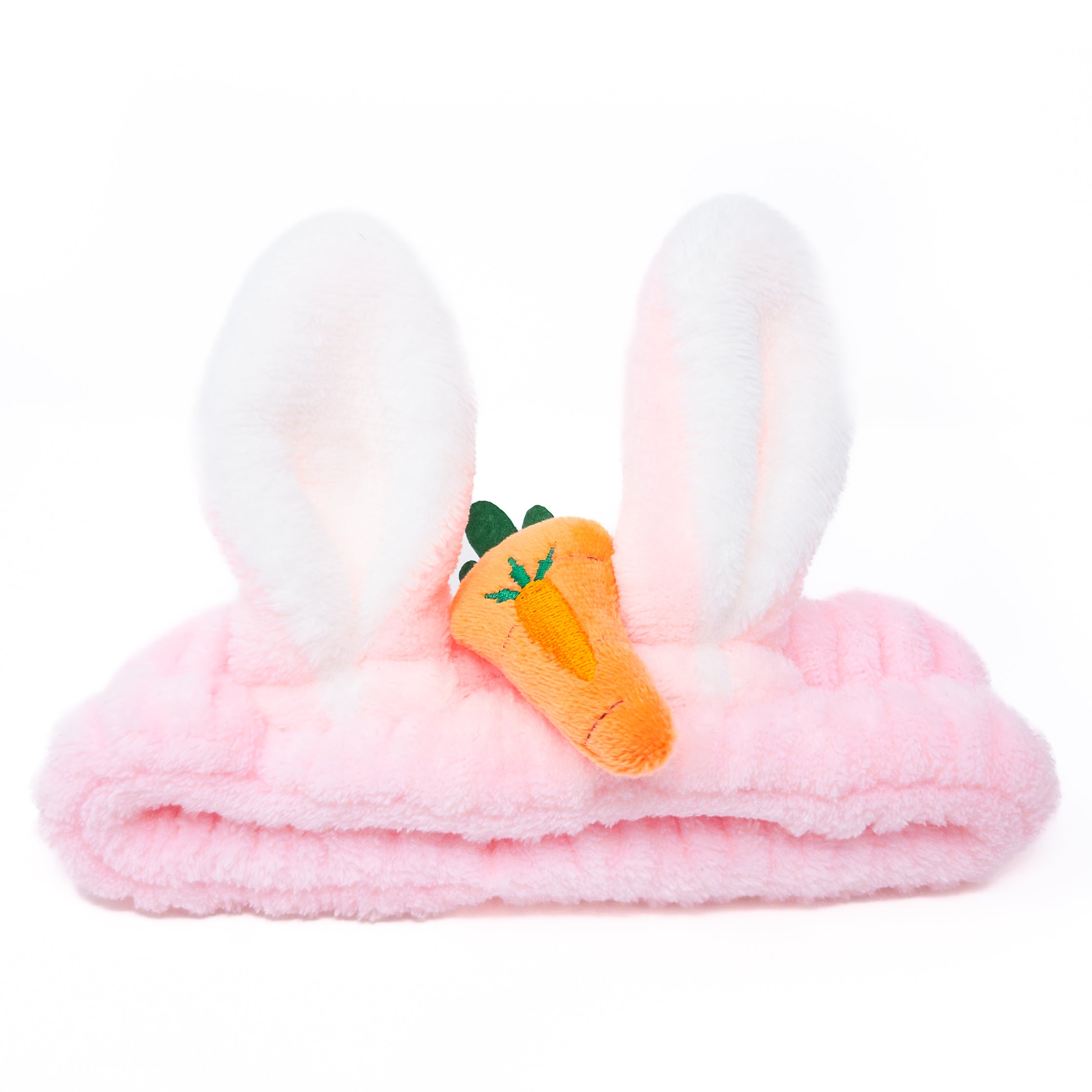 Pink fuzzy headband with bunny ears and carrot plushie.