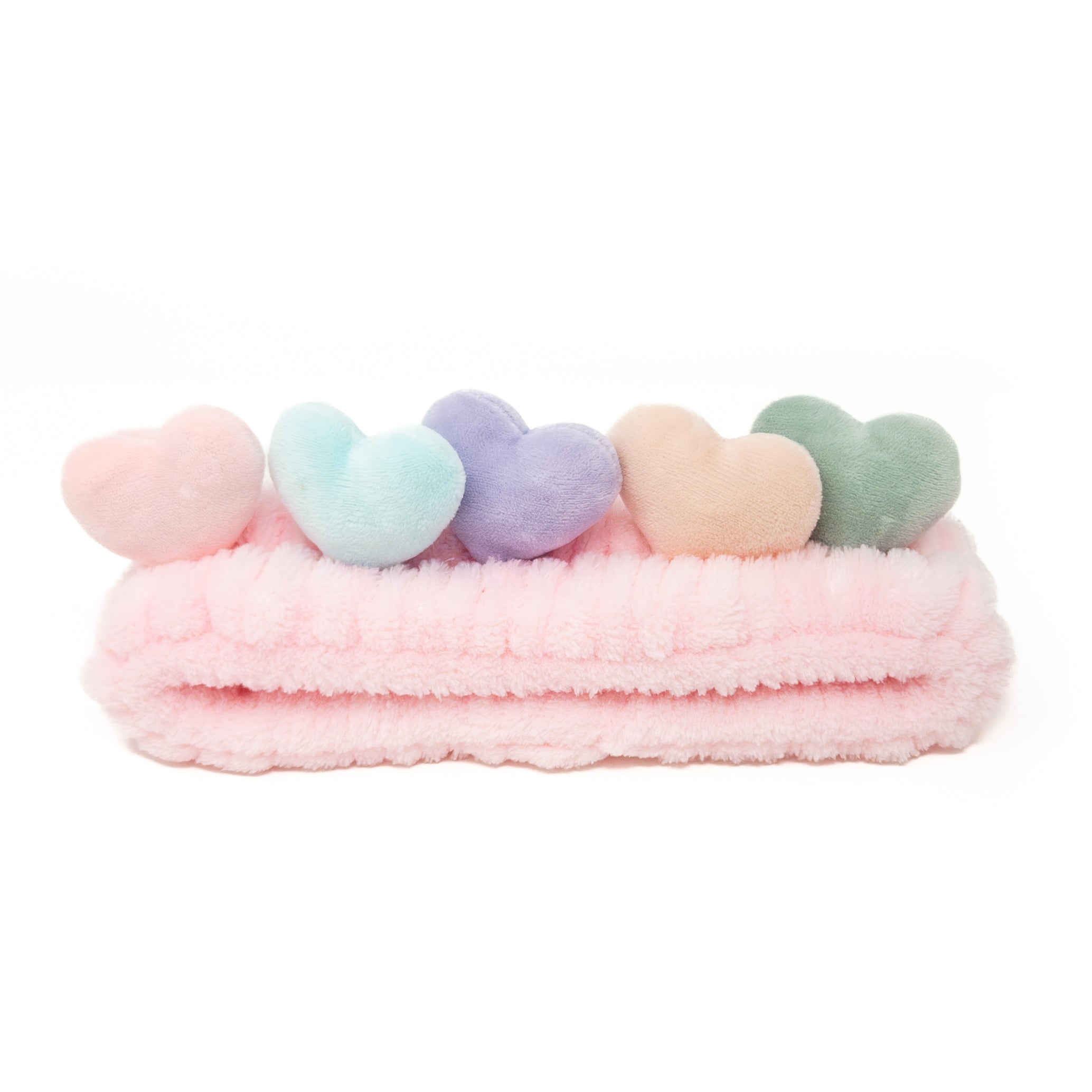 Pink plush headband with five heart-shaped decorations.