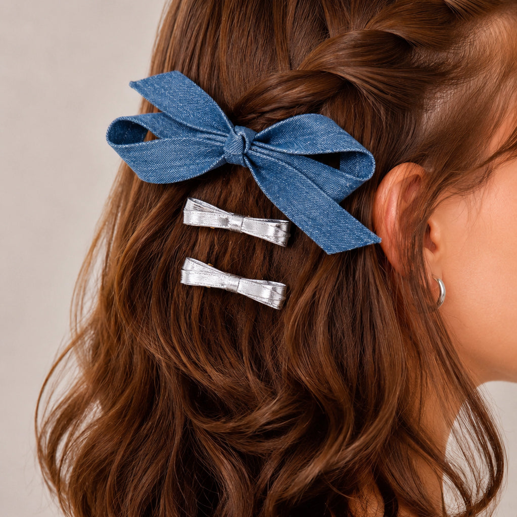 Three-piece bow clip set in light denim and silver, styled in wavy brown hair.
