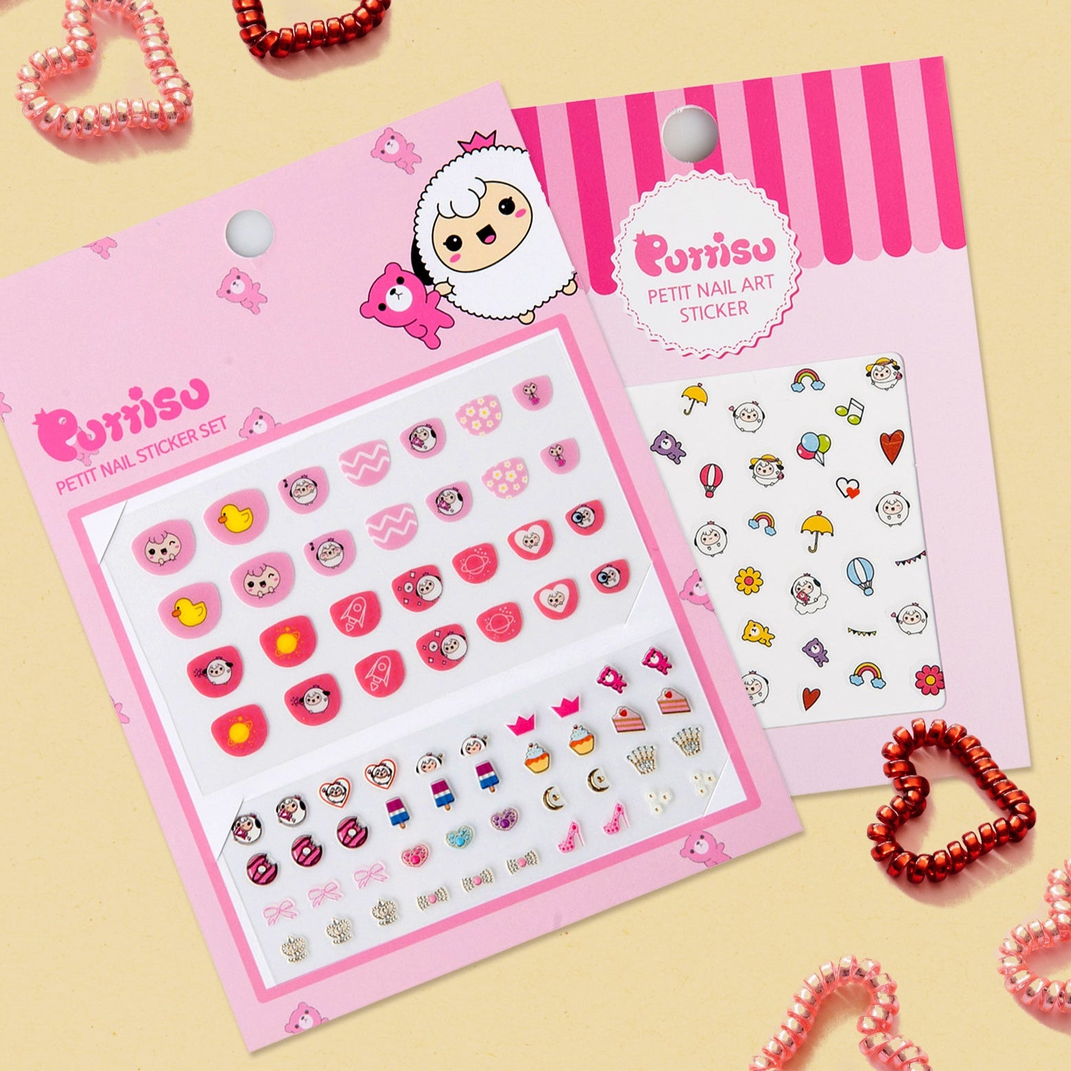 Two packs of Purriso petit nail stickers on a pale yellow background, with heart-shaped coil hair ties.