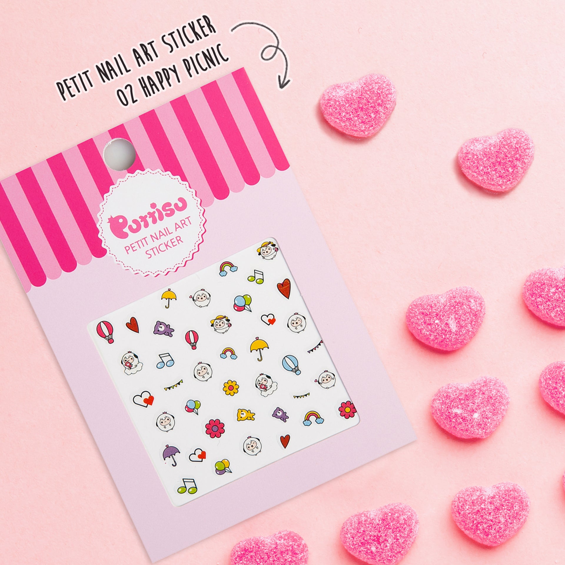 Overhead studio shot of pink Petit Nail Art Sticker with pink candy hearts on pink background.