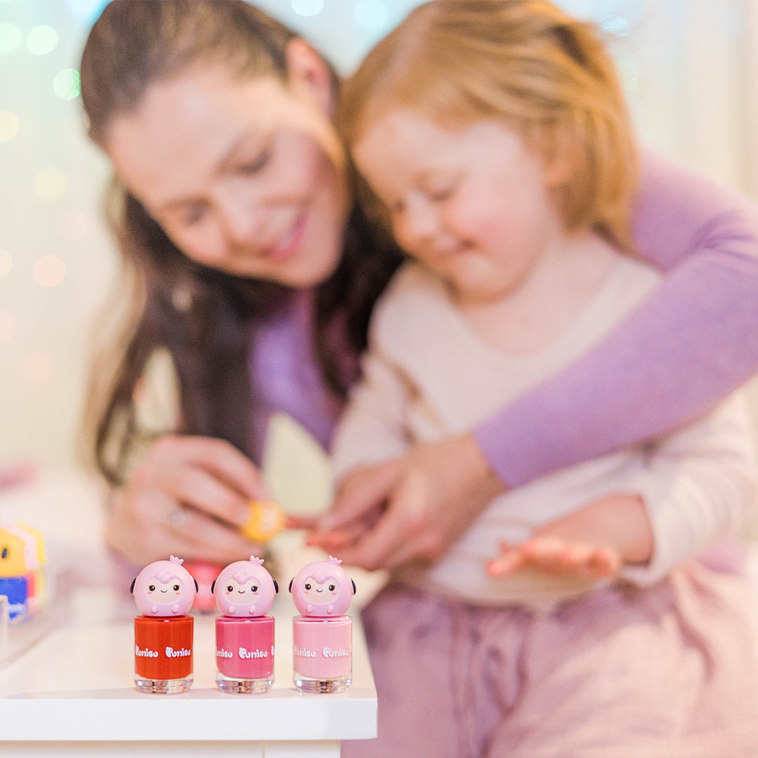 A mother and daughter playing with colorful nail polish.