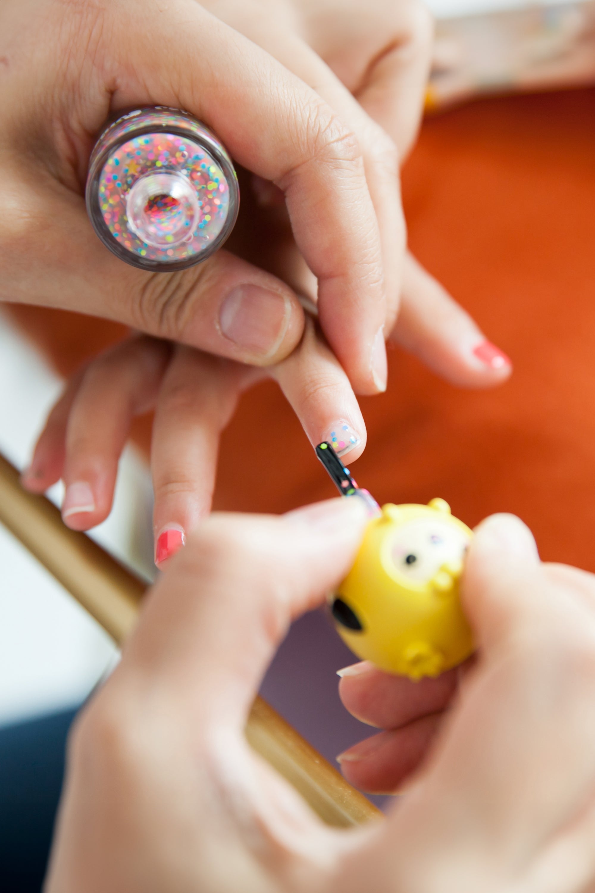 Person applying glitter nail polish.