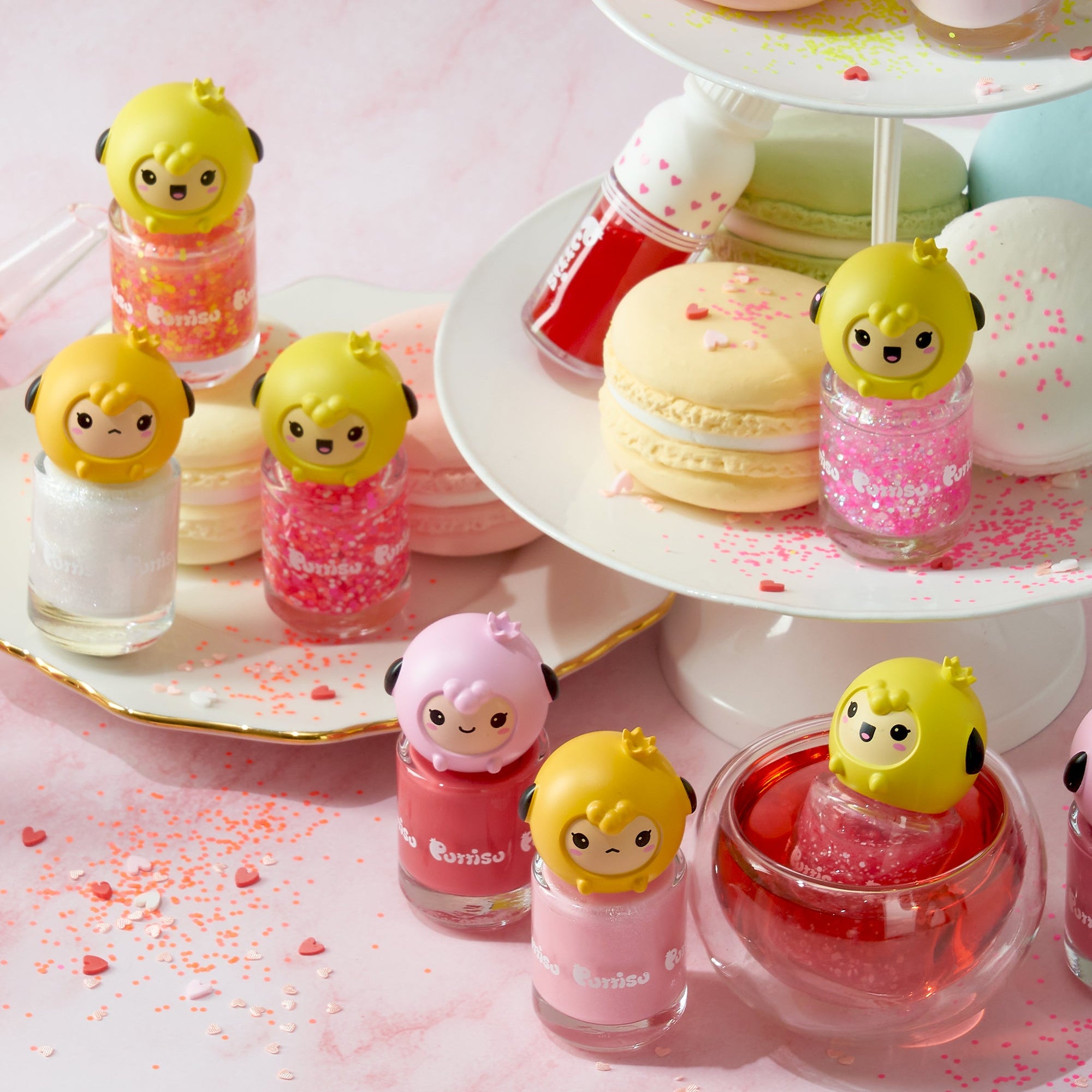 Assorted Purriso nail polishes with cartoon toppers and macarons.