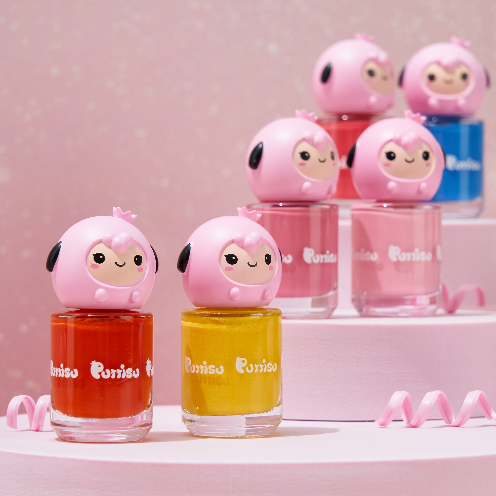 Colorful nail polish bottles with pink sheep-shaped caps on a pink tiered platform.