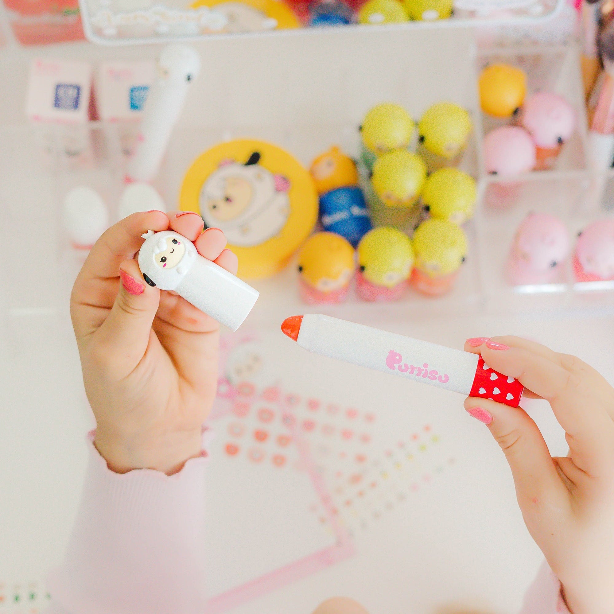 Hands holding a Puniso pen with a heart-patterned cap.