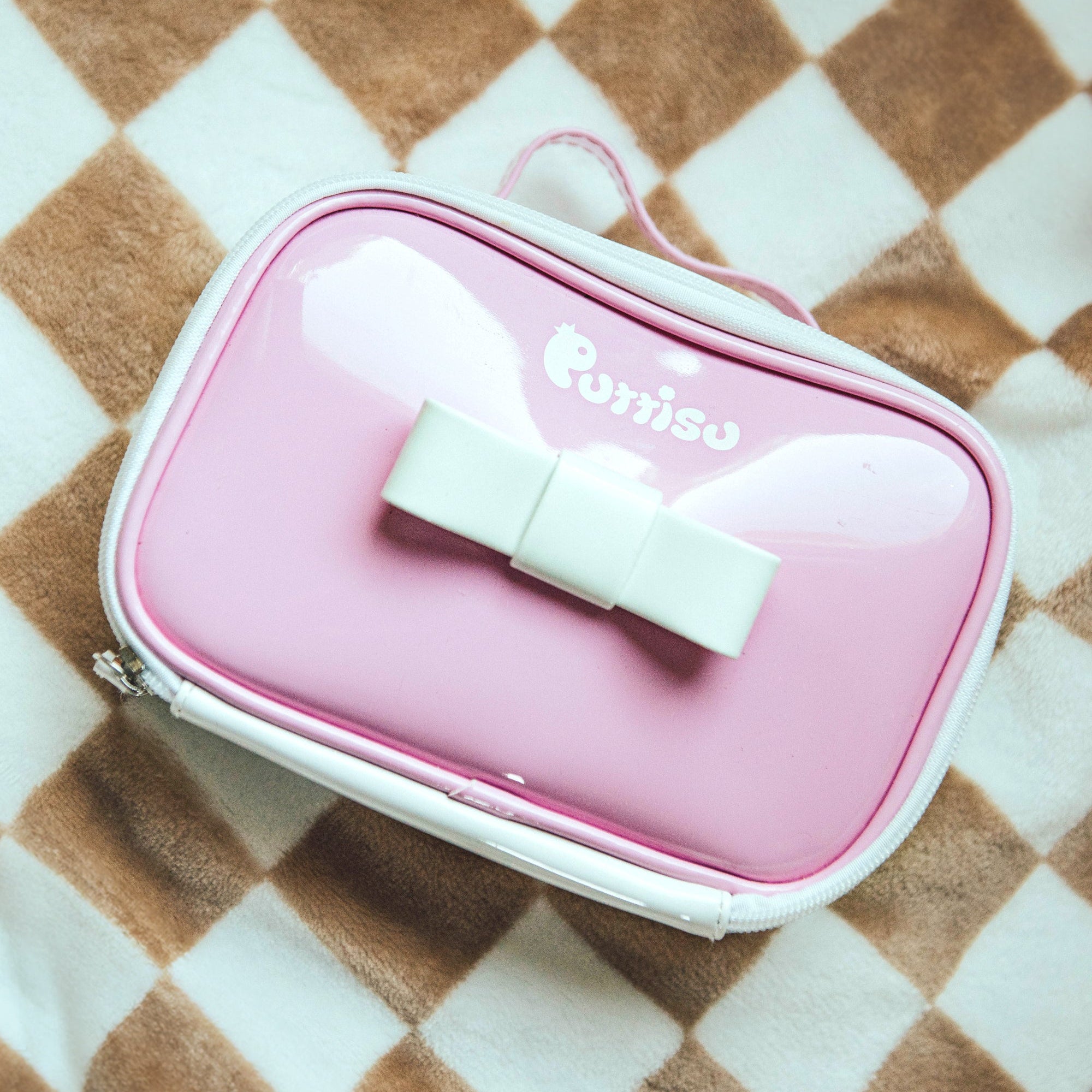 Pink makeup bag with white bow.