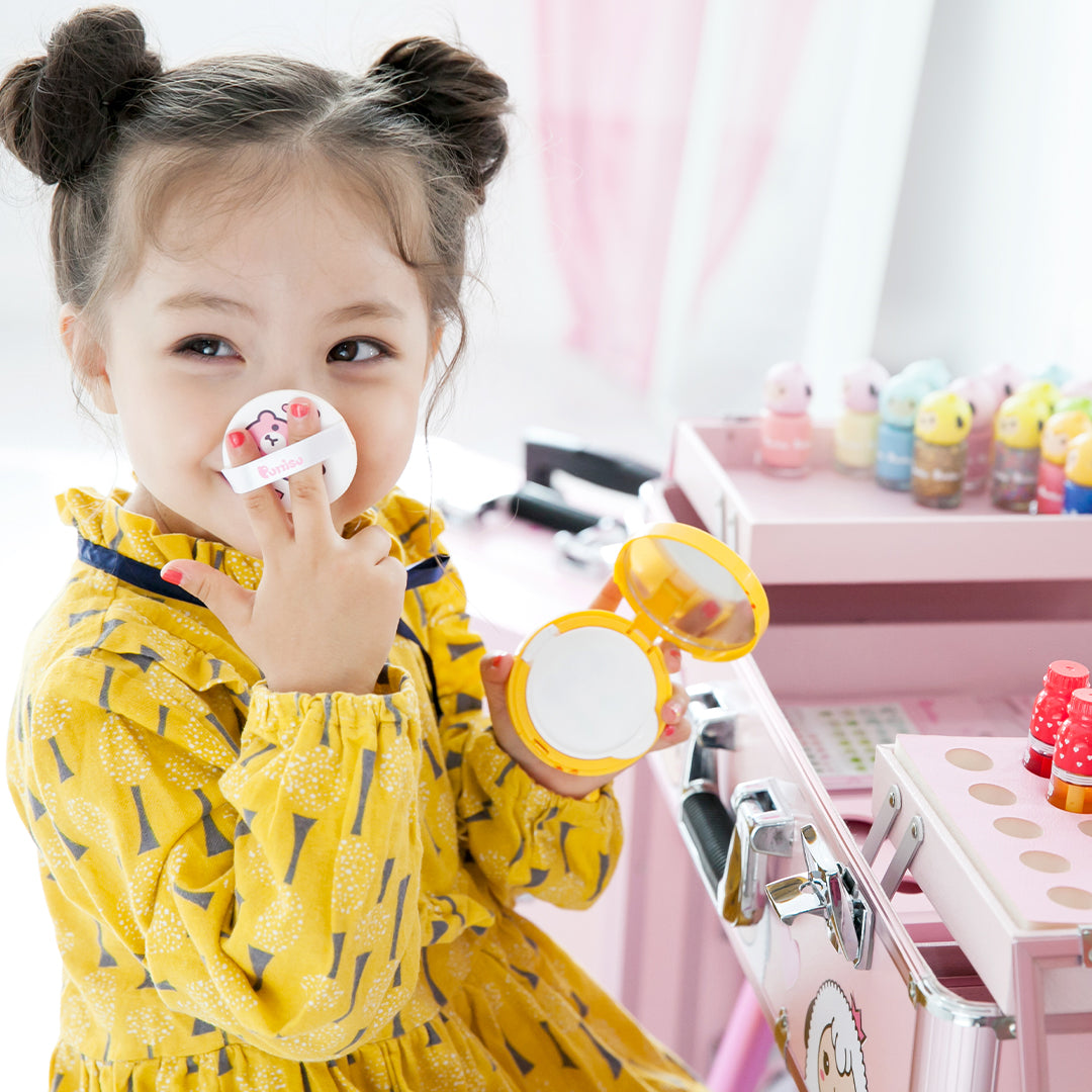 Young girl in yellow dress applying makeup with compact and applicator.