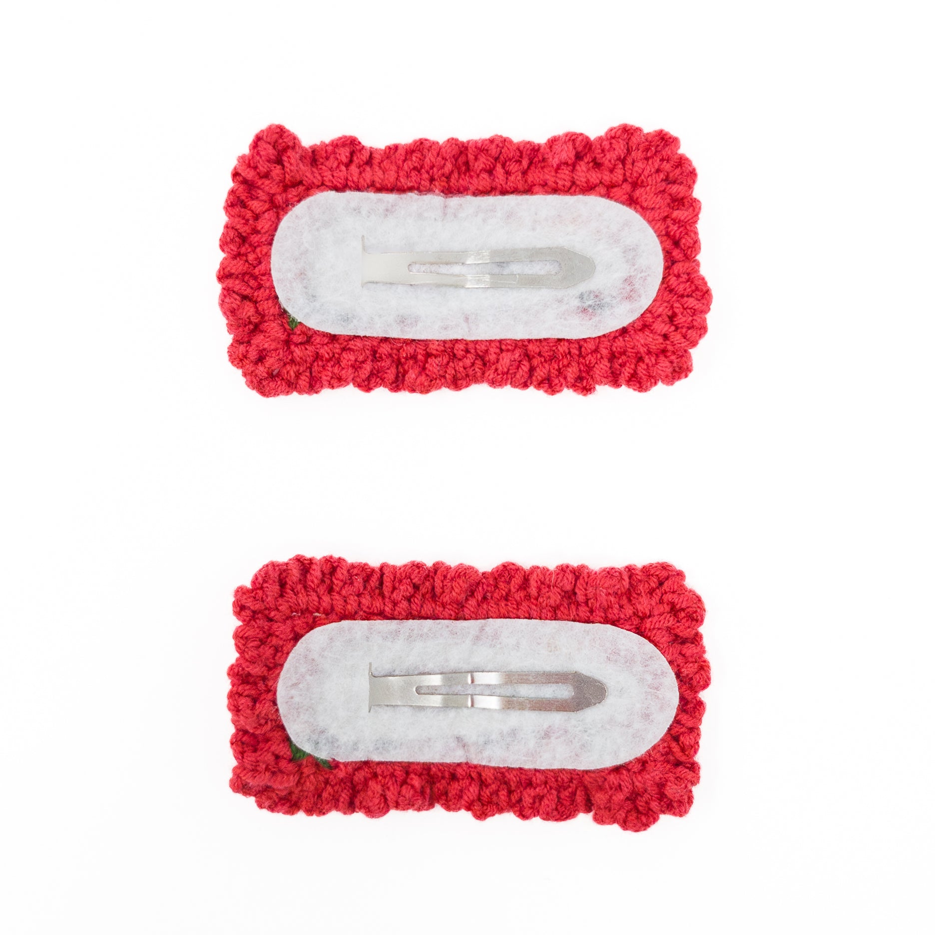 Two red crocheted hair clips with metal fasteners.