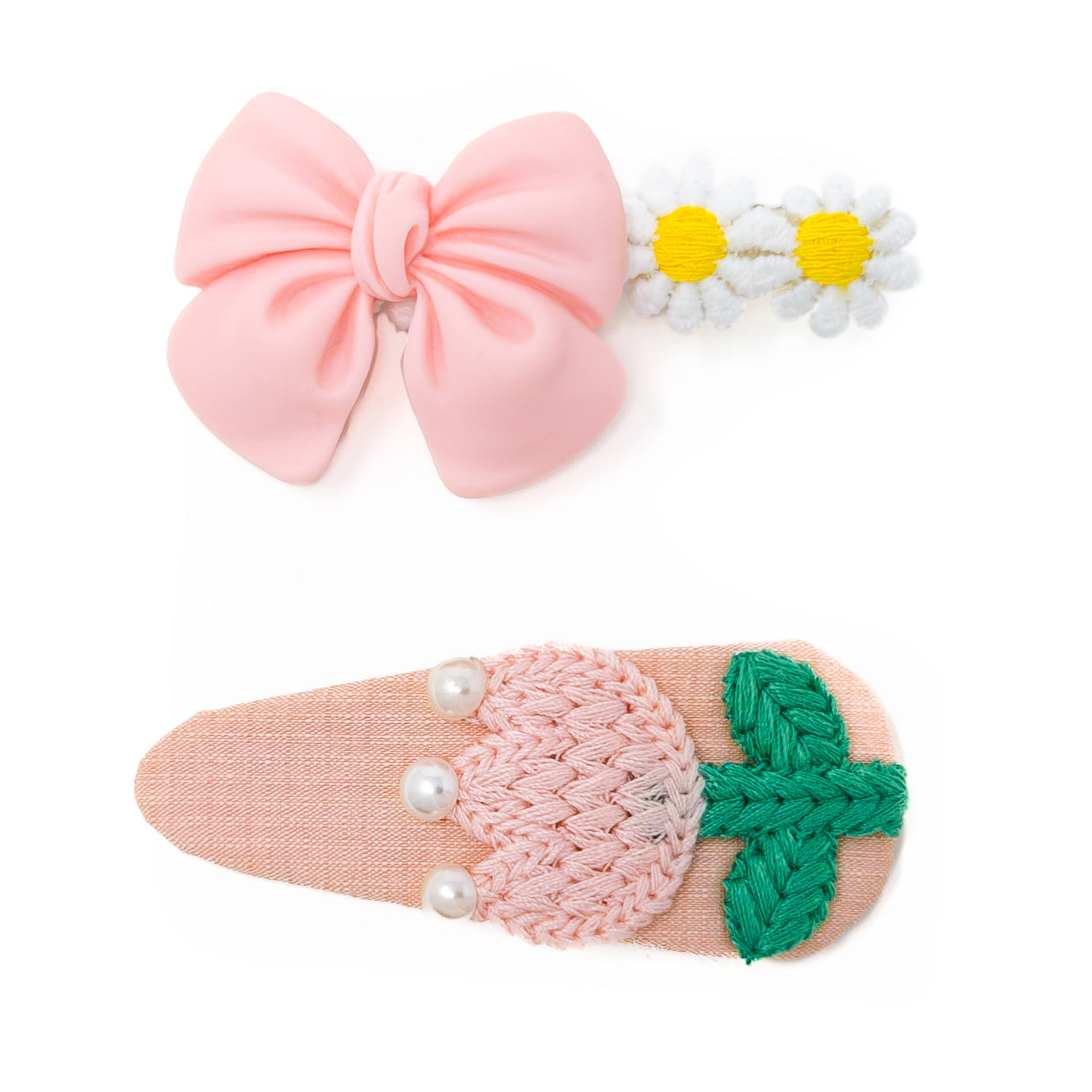 Two colorful hair clips with different designs: a pink bow with daisies and a pink and green knitted strawberry.