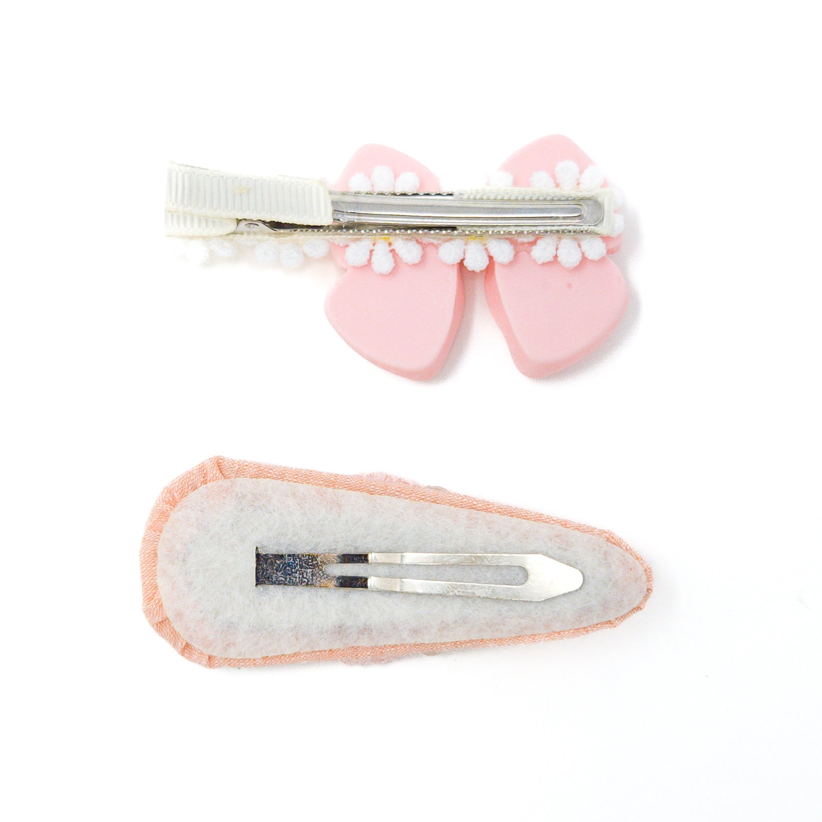 Two hair clips. One with a pink bow and white trim, the other with a pink edge.