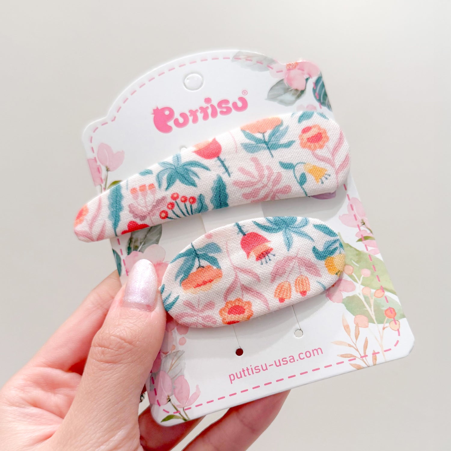 Two floral fabric hair clips on a card.