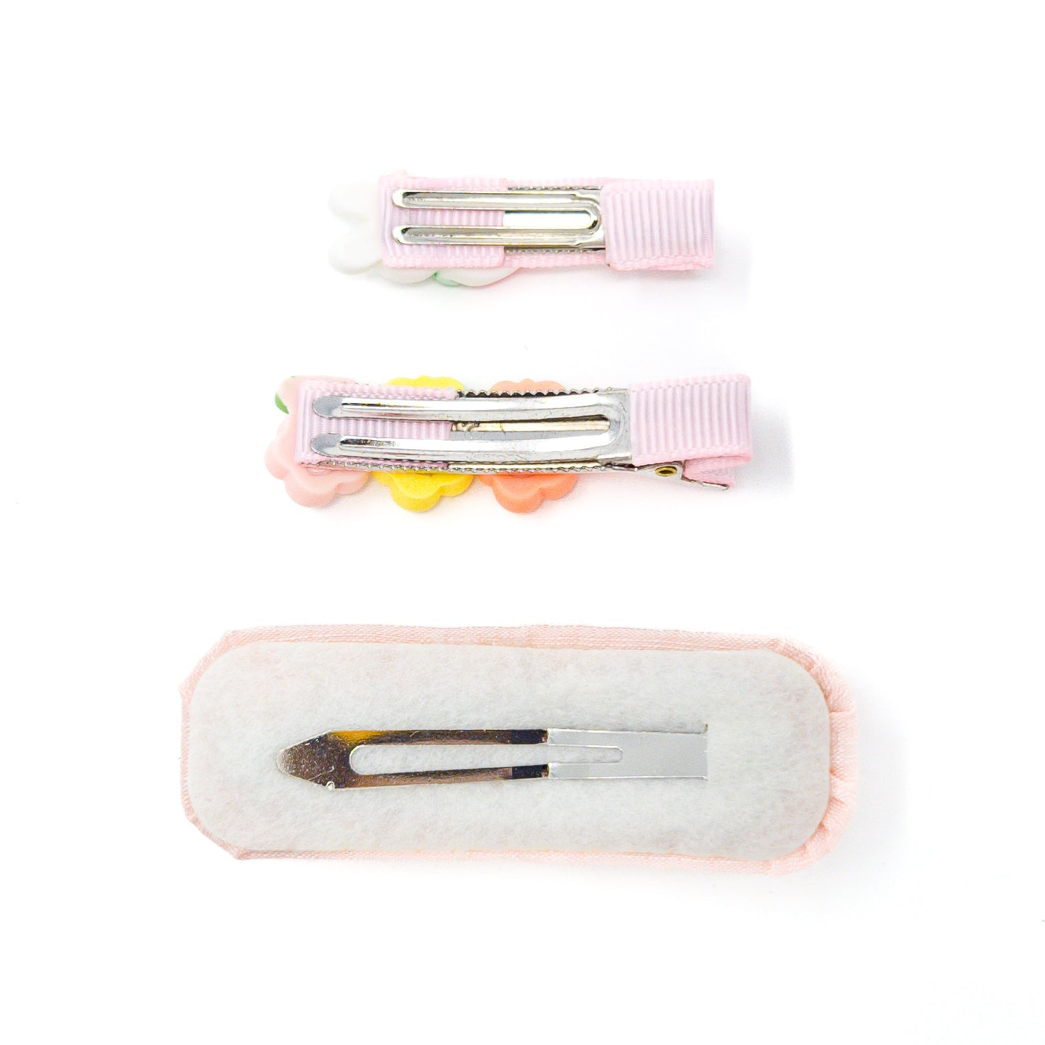 Three hair clips with pink fabric and metal fasteners on a white background.
