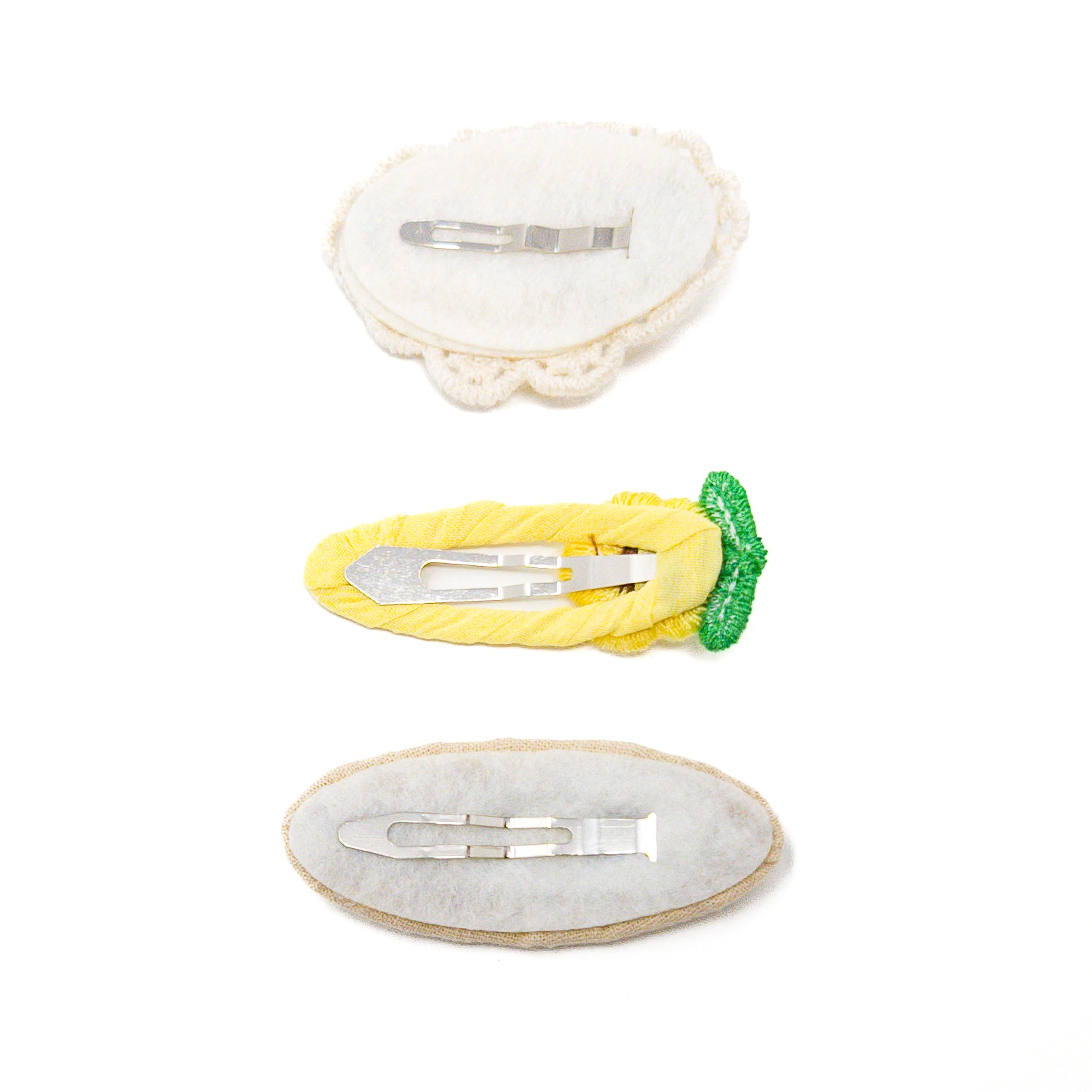 Three fabric-covered hair clips with metal fasteners, isolated on white.