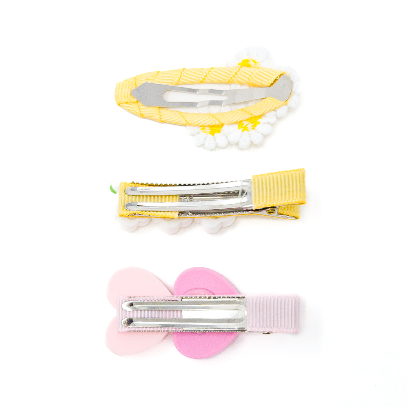 Three hair clips with silver fasteners, adorned with yellow, white, and pink fabric details, on a white background.