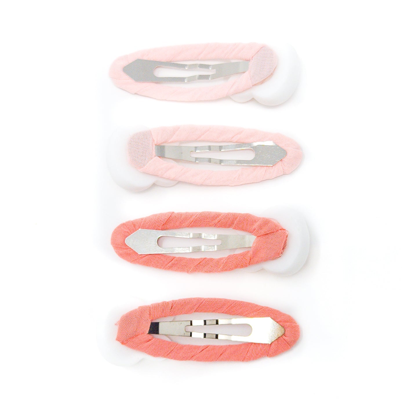 Four fabric-covered hair clips in graduated shades of pink and peach with metal fasteners, arranged vertically.