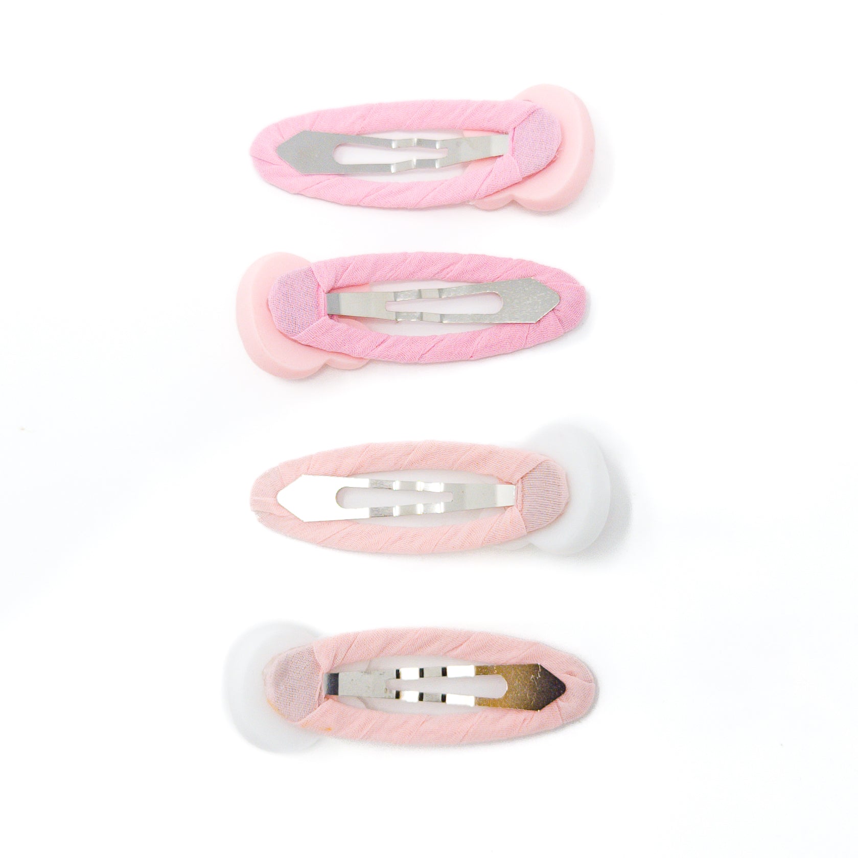 Four pink, fabric-covered hair clips on white.