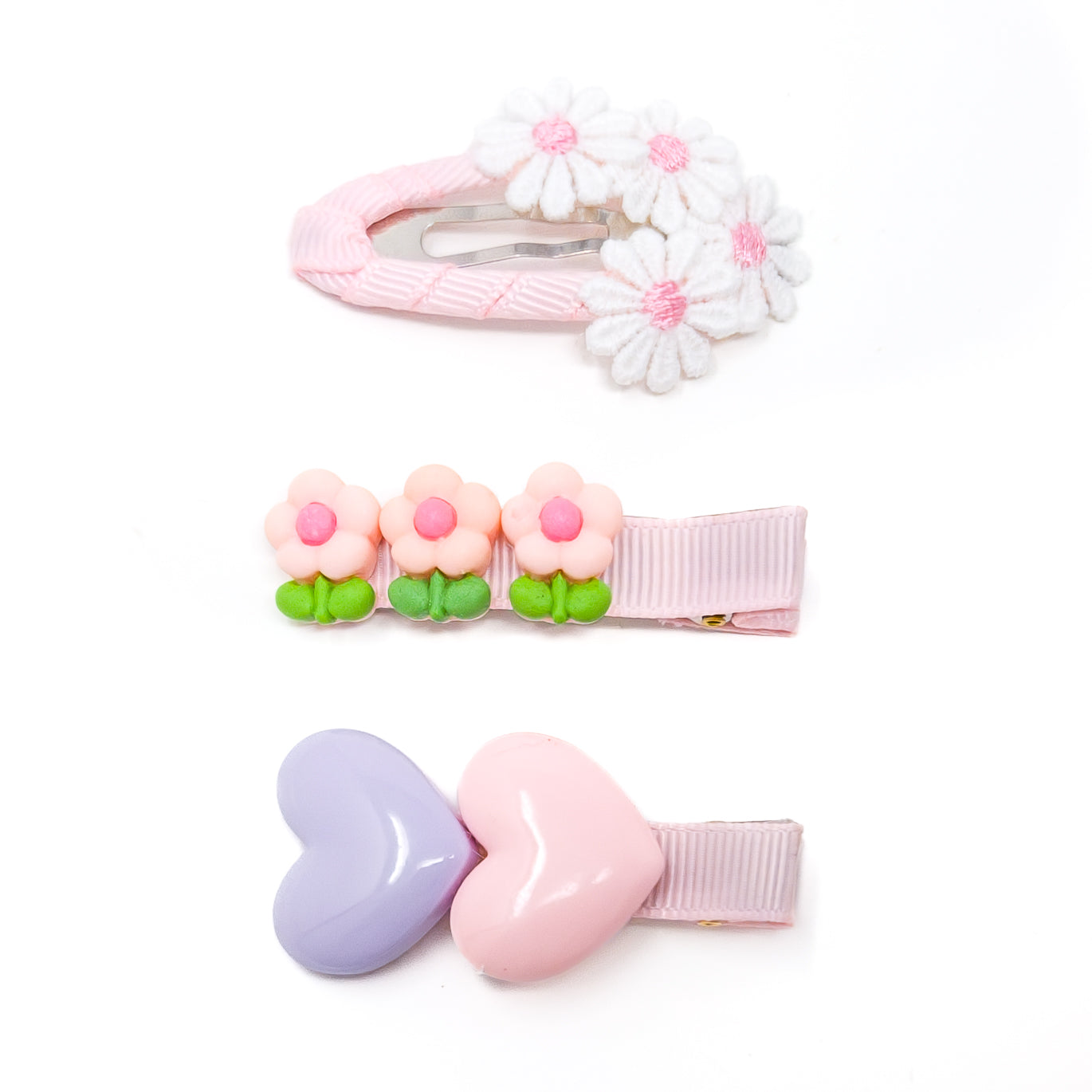 Three sets of hair clips. Pink, white, and lavender colors. Floral and heart shapes. Ribbons and metal clips.