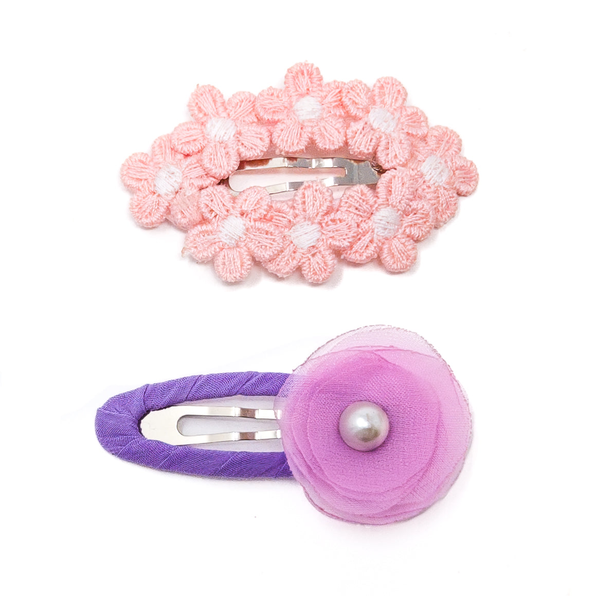 Two floral hair clips, one pink with multiple flowers, the other purple with a single flower and pearl.