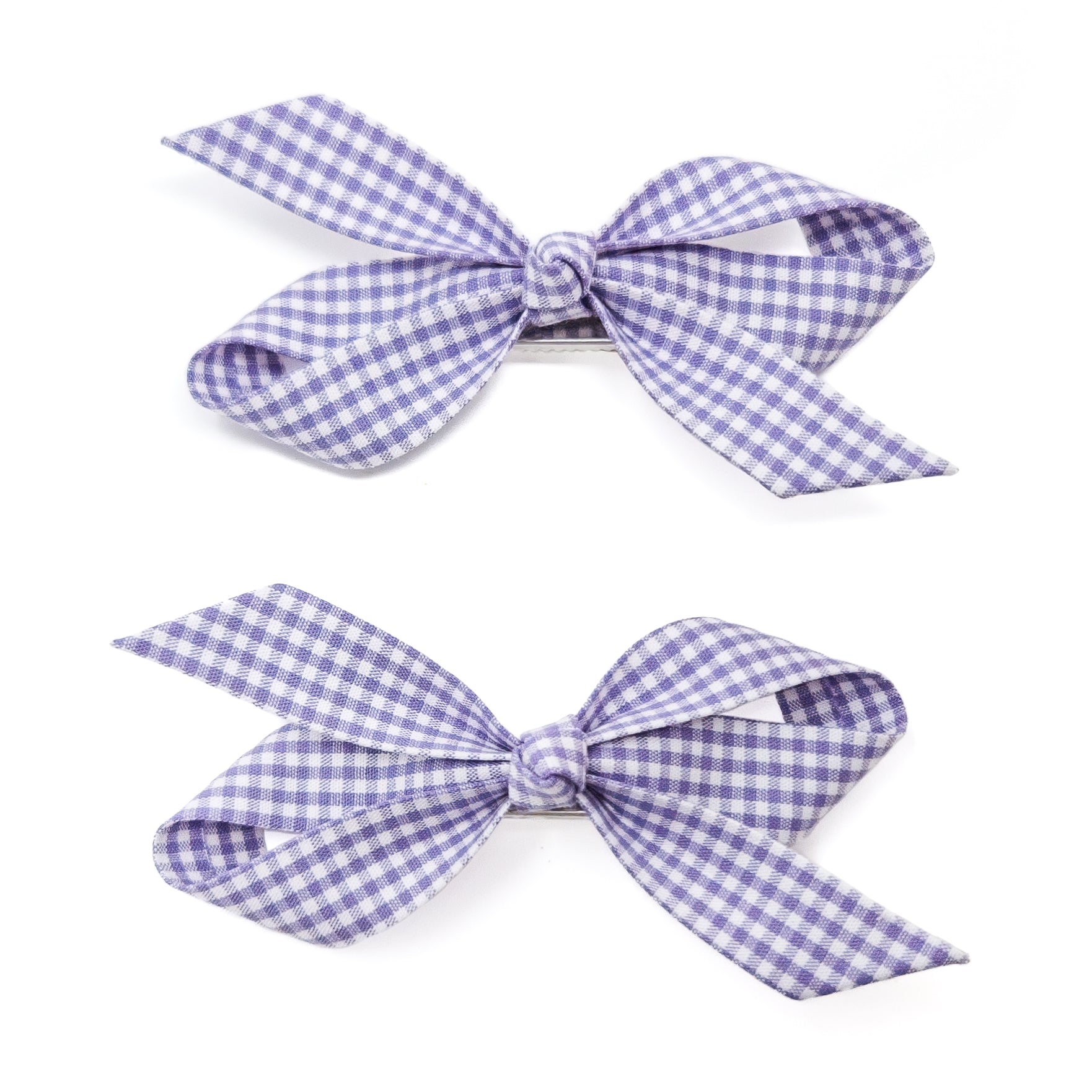 Two purple and white checkered bow hair clips on a white background.