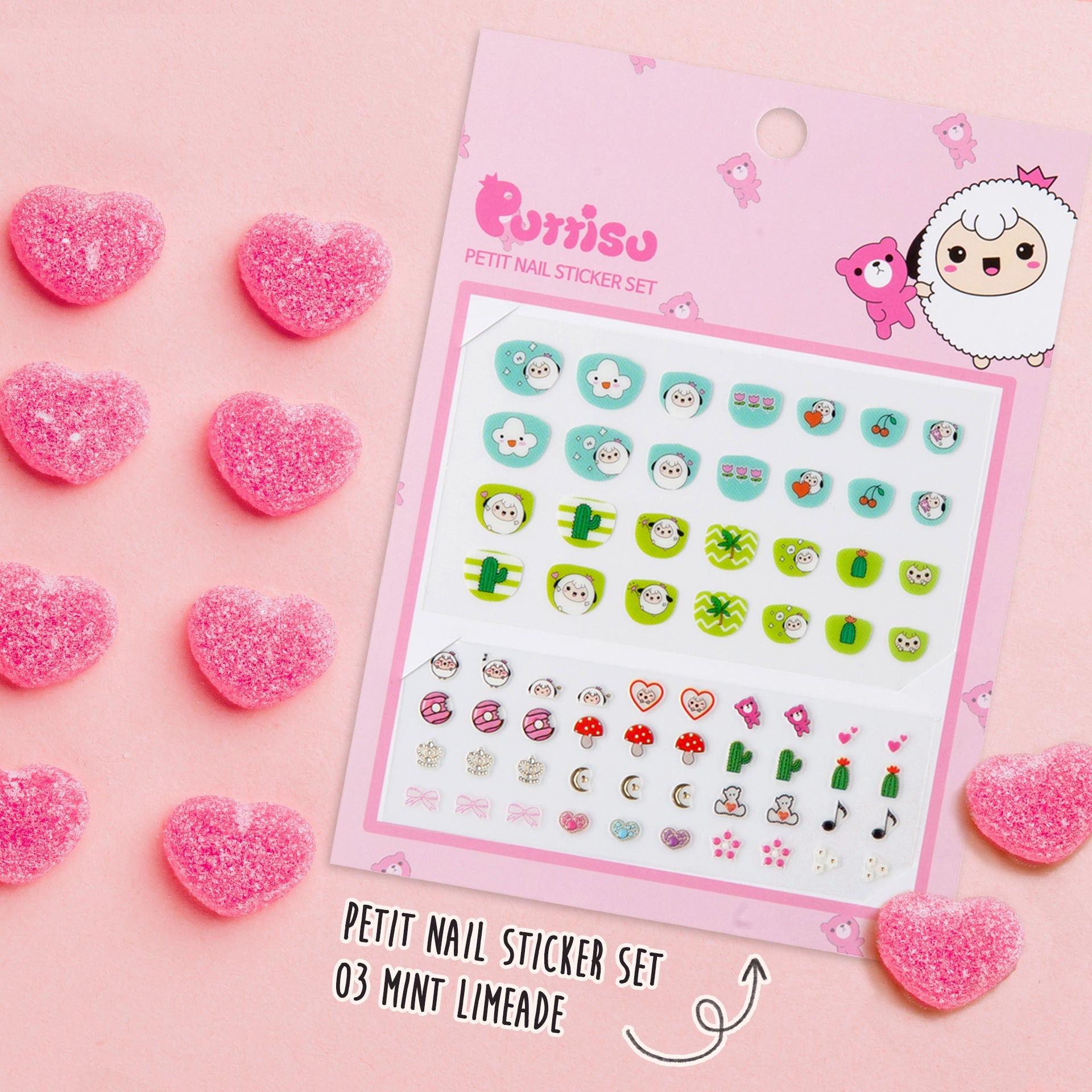 A pink package of nail stickers with cartoon designs surrounded by pink, heart-shaped candies.