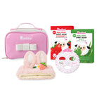 Pink cosmetic bag with bunny ears, strawberry, and aloe vera sheet masks on a white background
