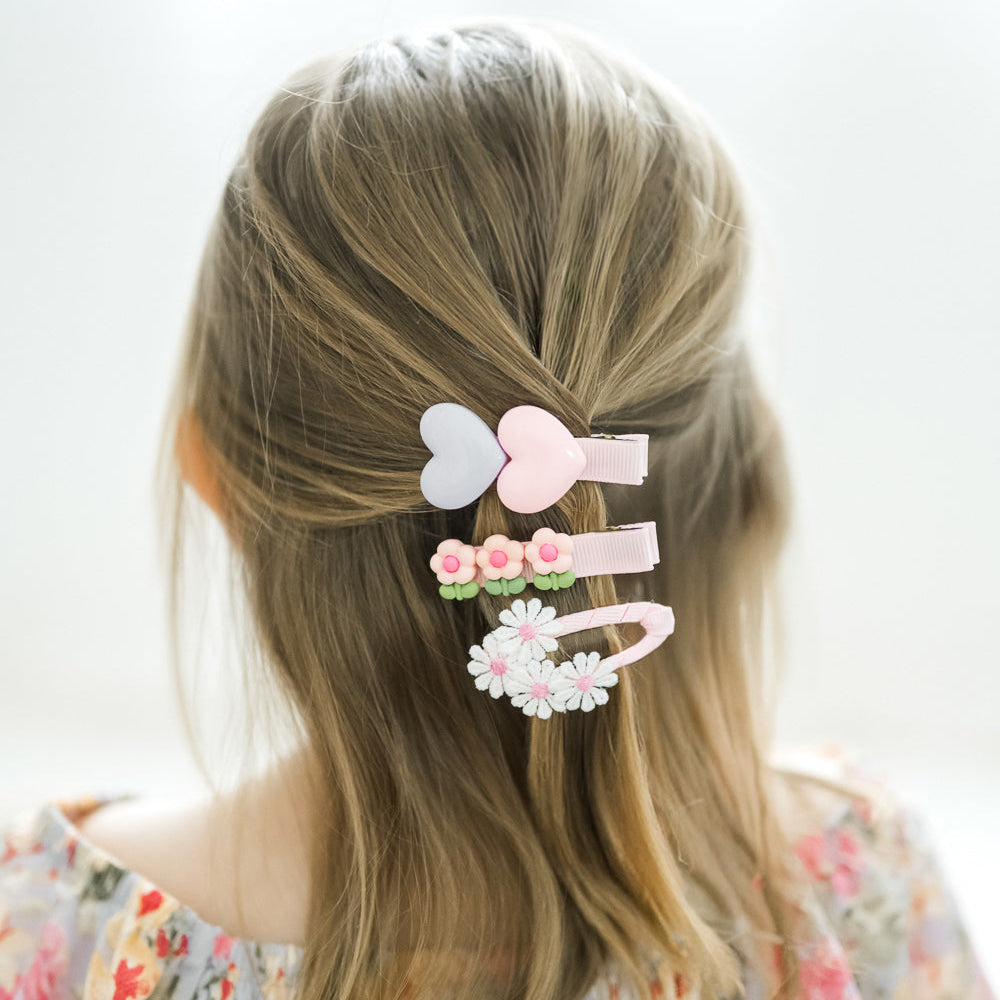Set of colorful hair clips on a child's head with a plain background