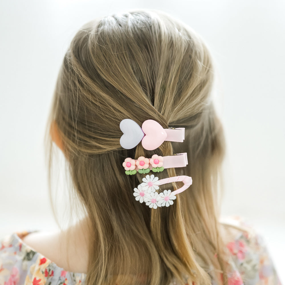 Set of colorful hair clips on a child's head with a plain background