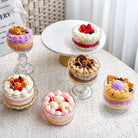 Jellycup cake soy wax candles with dessert toppings on a textured white tablecloth.