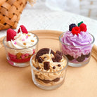 Three small dessert cupcake candles with different flavors on a beige surface.