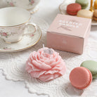 Pink Peonie flower soy wax candle by Jellycup, with a white label and macarons on a lace mat.