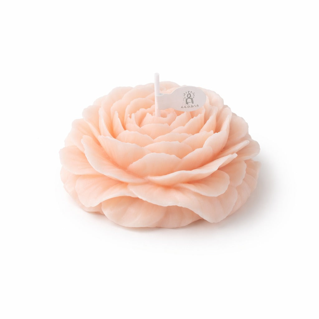 Peach-colored peony flower soy wax candle from Jellycup with a decorative white label.