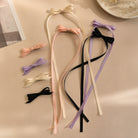 Ivory ribbon bow clip set, featuring peach, lavender, and black bow clips and long ties on a light background.