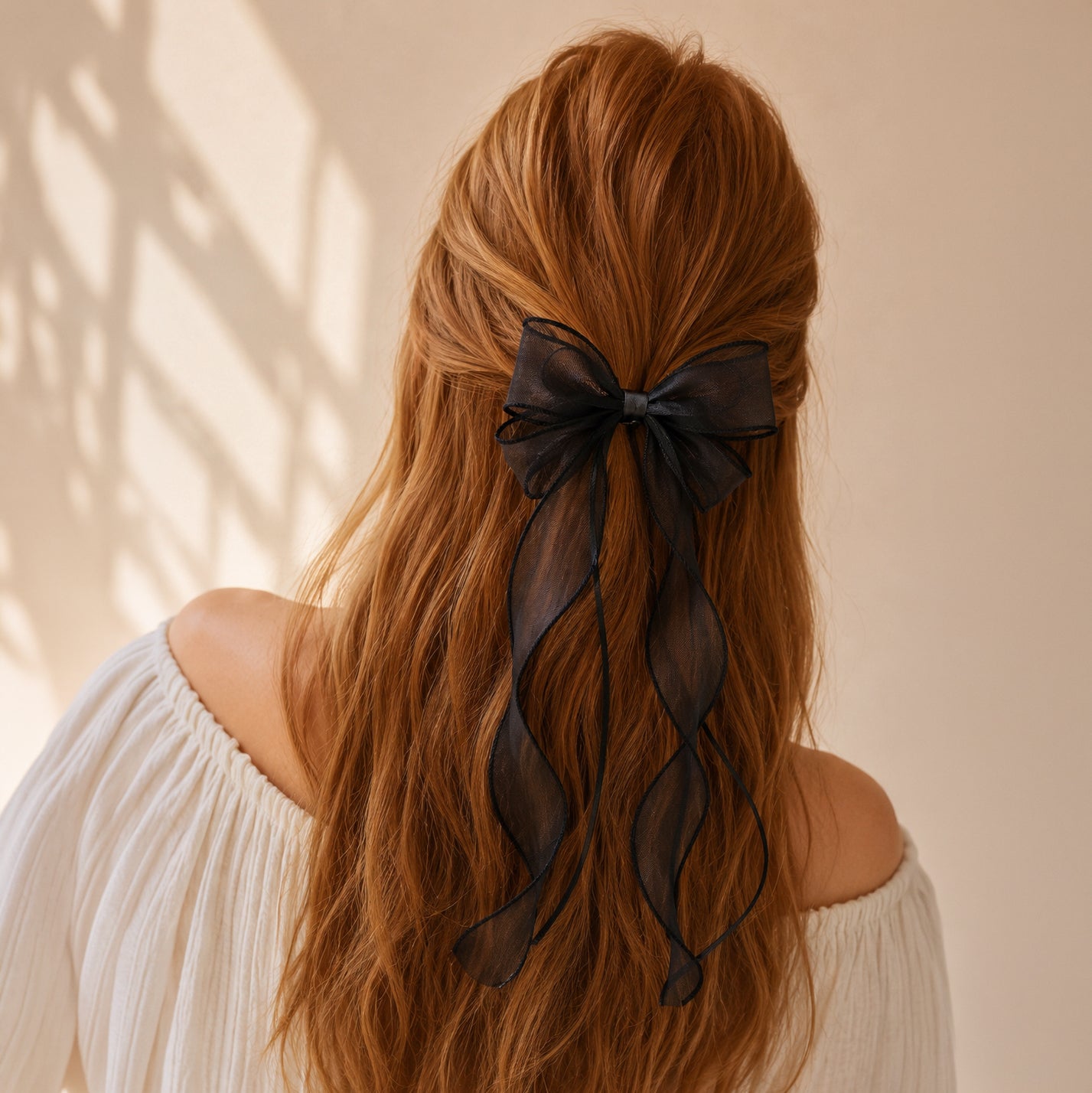 Black organza double ribbon clip with long flowing ribbons, styled in auburn hair from a back view.