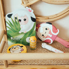 A curated shelf displays Purriso beauty products: an aloe face mask, compact, glitter nail polish, hairbrush, and crayon-like tool.