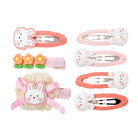 Seven Bunny Hug children's hair clips: a large bunny, a floral, a crocheted bunny, and four smaller oval bunny clips in pink and coral.